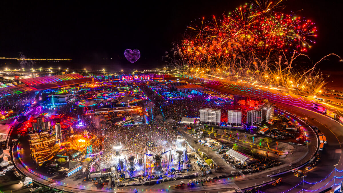 Aerial view of a massive electronic music festival with multiple stages and tens of thousands of attendees illustrating the scale of modern mega-events